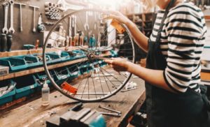 woman holding wheel in bike shop